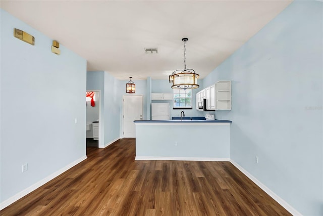 kitchen with a peninsula, visible vents, white cabinetry, freestanding refrigerator, and open shelves