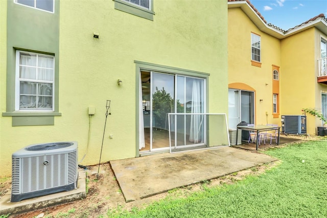 rear view of property with a patio area, stucco siding, and central air condition unit