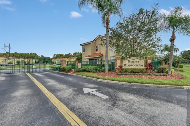 view of street with curbs, a gated entry, and a gate