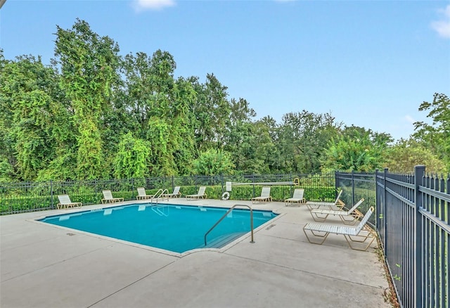 pool with a patio area and fence