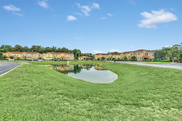 view of property's community featuring a residential view, a water view, and a lawn