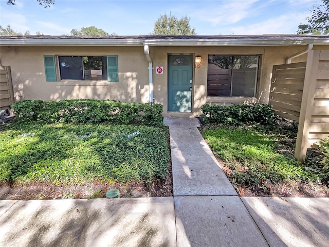 doorway to property featuring stucco siding