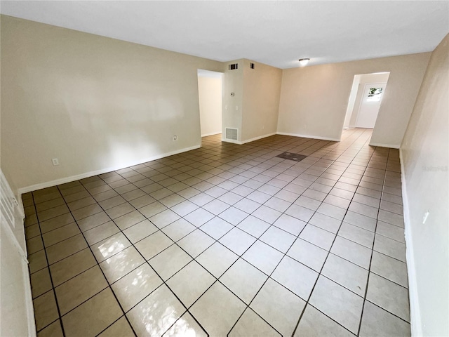 unfurnished room with light tile patterned floors, baseboards, and visible vents