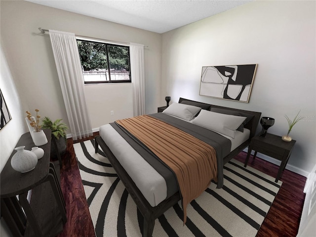 bedroom featuring a textured ceiling, baseboards, and wood finished floors