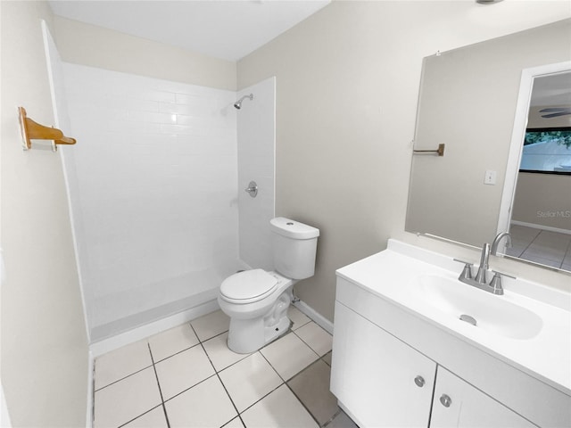 full bath with baseboards, toilet, tile patterned flooring, a tile shower, and vanity