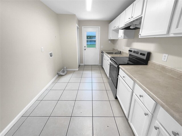 kitchen with sink, light tile patterned floors, appliances with stainless steel finishes, and white cabinets