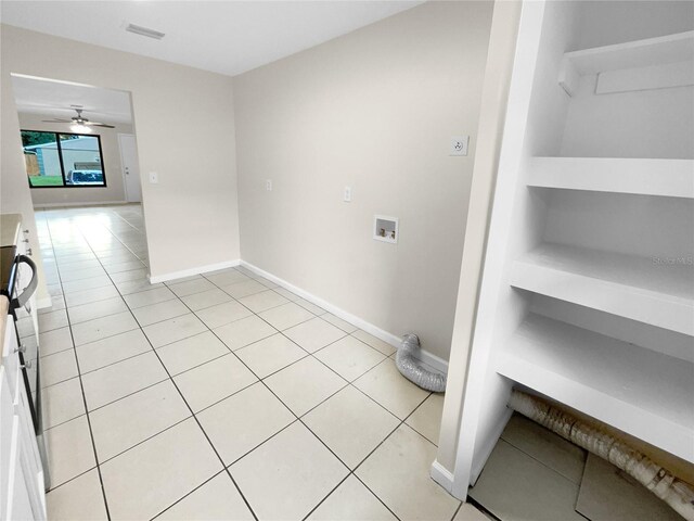 interior space featuring washer hookup, ceiling fan, and light tile patterned flooring