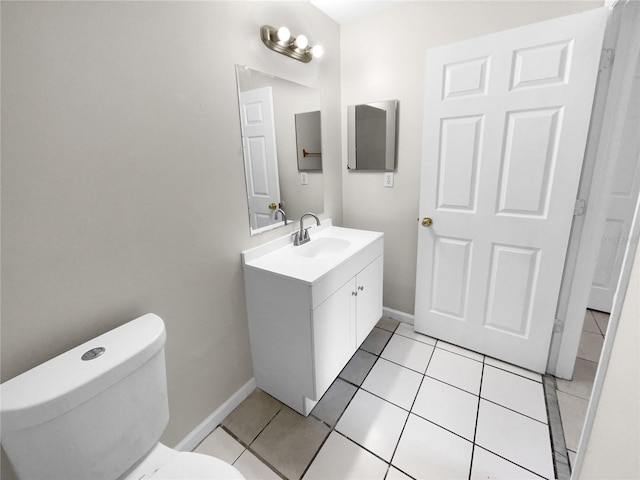 bathroom featuring baseboards, vanity, toilet, and tile patterned floors