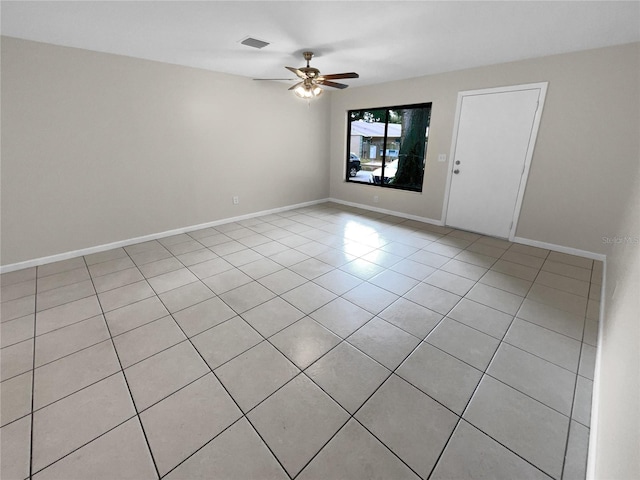 spare room with a ceiling fan, visible vents, baseboards, and light tile patterned floors