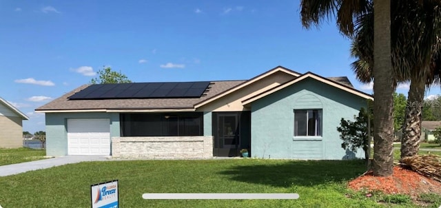 view of front facade with solar panels, a front yard, and a garage