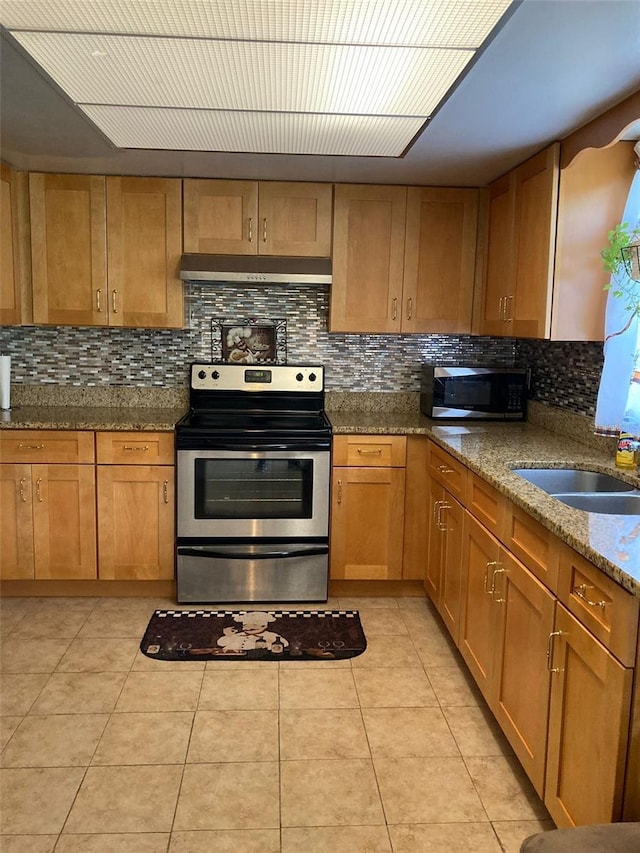 kitchen featuring light stone counters, range hood, stainless steel appliances, light tile patterned floors, and decorative backsplash