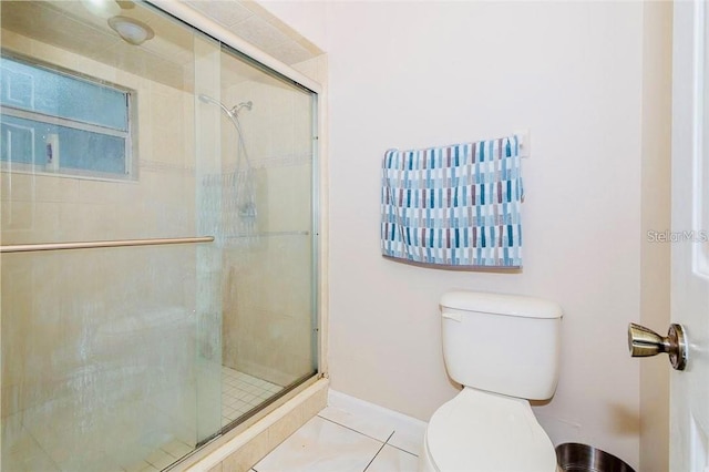 bathroom with tile patterned flooring, a shower with shower door, and toilet