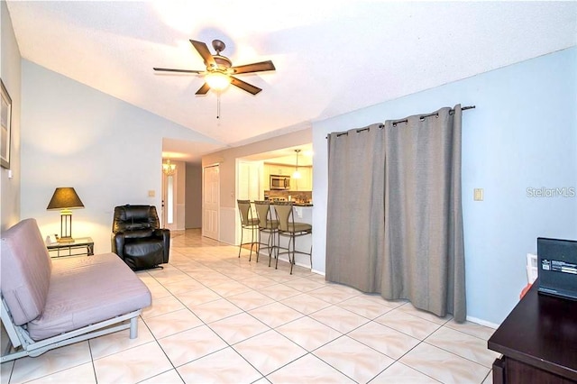 living room with ceiling fan, light tile patterned floors, and vaulted ceiling