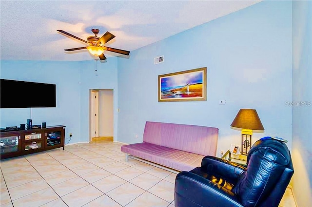 living room featuring a textured ceiling, ceiling fan, lofted ceiling, and light tile patterned flooring