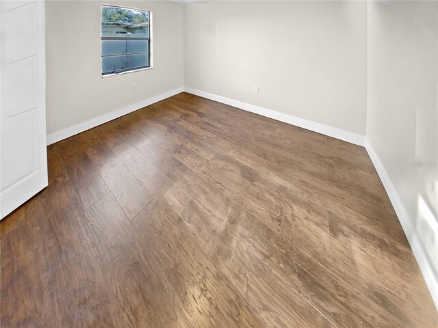 spare room with dark wood-type flooring