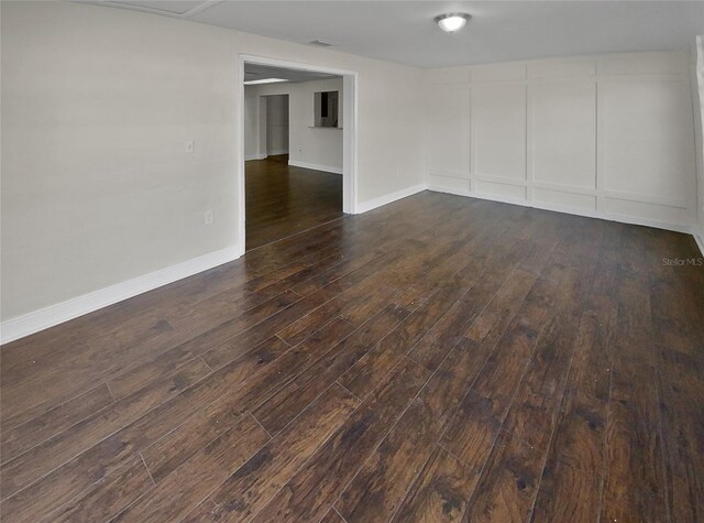 unfurnished room with dark hardwood / wood-style flooring