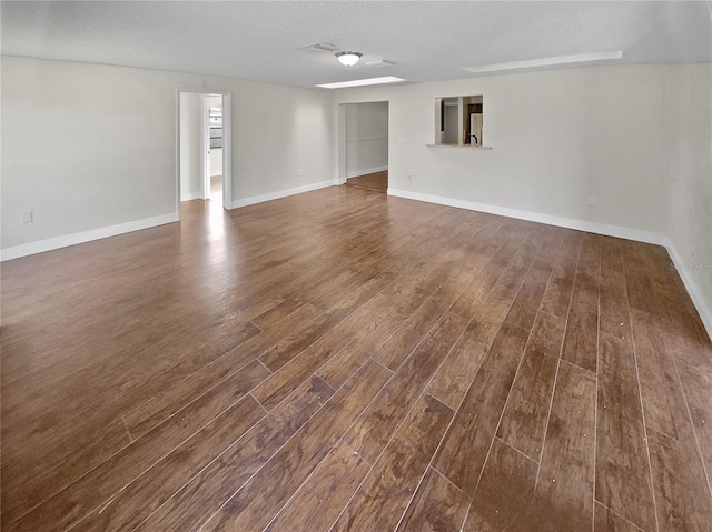 spare room featuring dark hardwood / wood-style floors and a textured ceiling