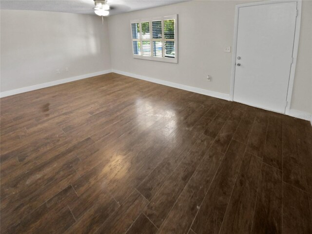 empty room featuring ceiling fan and dark hardwood / wood-style flooring