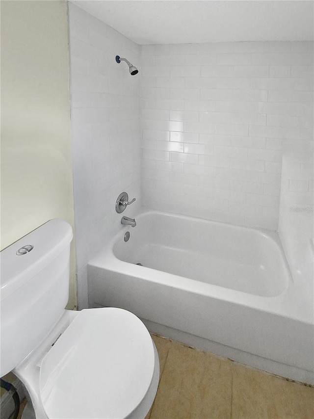 bathroom with tiled shower / bath combo, toilet, and tile patterned floors