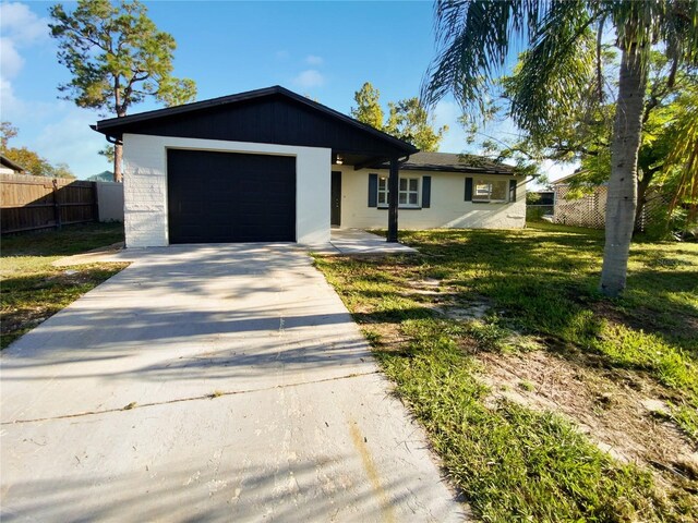 single story home featuring a garage and a front lawn