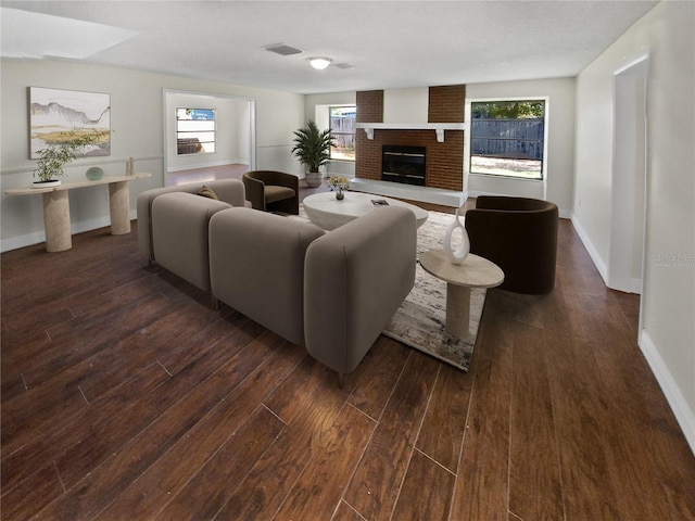 living room with dark hardwood / wood-style flooring and a fireplace