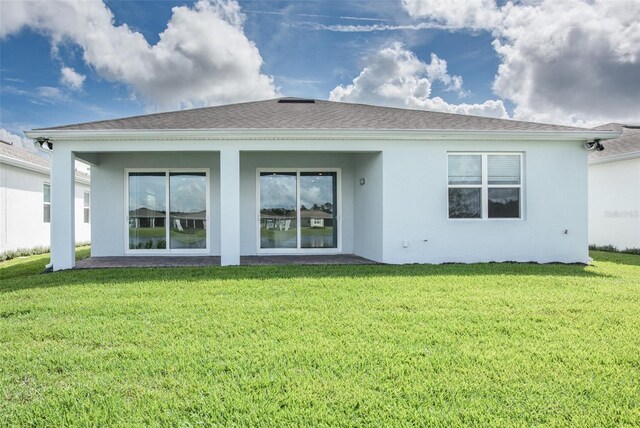 rear view of house featuring a lawn