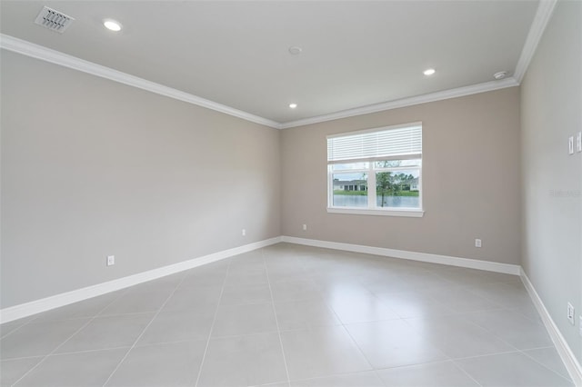 spare room featuring crown molding and light tile patterned floors