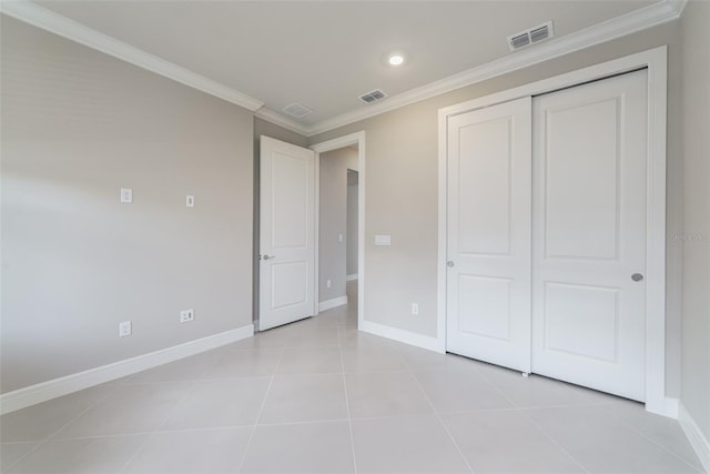 unfurnished bedroom with a closet, ornamental molding, and light tile patterned floors