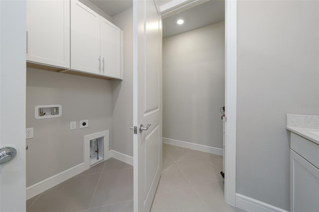 washroom with hookup for a washing machine, cabinets, light tile patterned floors, and electric dryer hookup