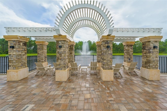 view of patio / terrace with a pergola and a water view