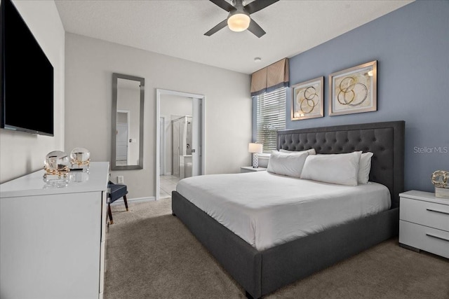 bedroom featuring dark colored carpet, ensuite bathroom, ceiling fan, and a textured ceiling