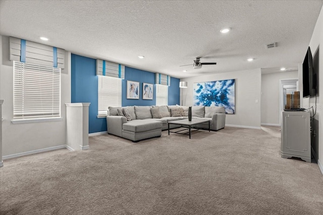 carpeted living room featuring a textured ceiling and ceiling fan