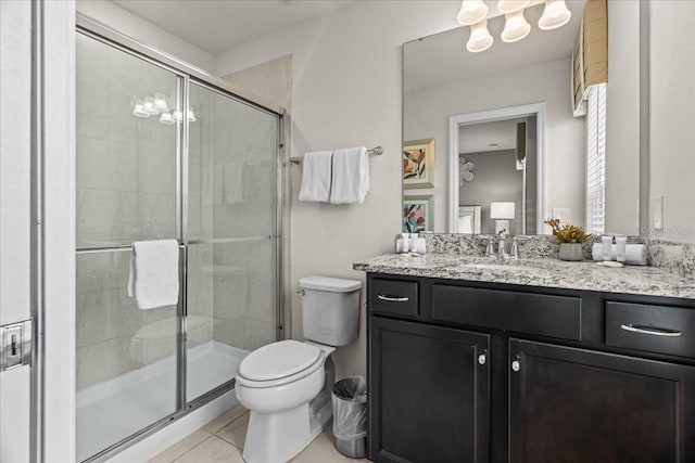 bathroom featuring a shower with door, vanity, tile patterned flooring, and toilet