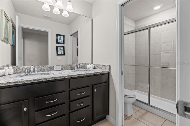 bathroom with tile patterned flooring, vanity, an enclosed shower, a textured ceiling, and toilet