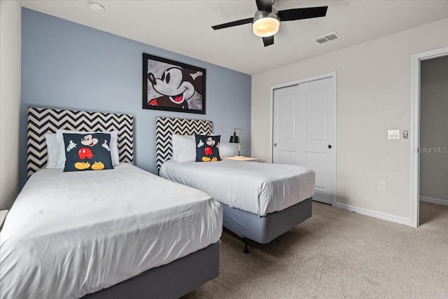 carpeted bedroom with ceiling fan and a closet