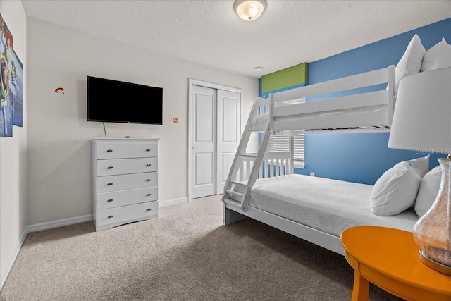 bedroom with carpet, a closet, and a textured ceiling