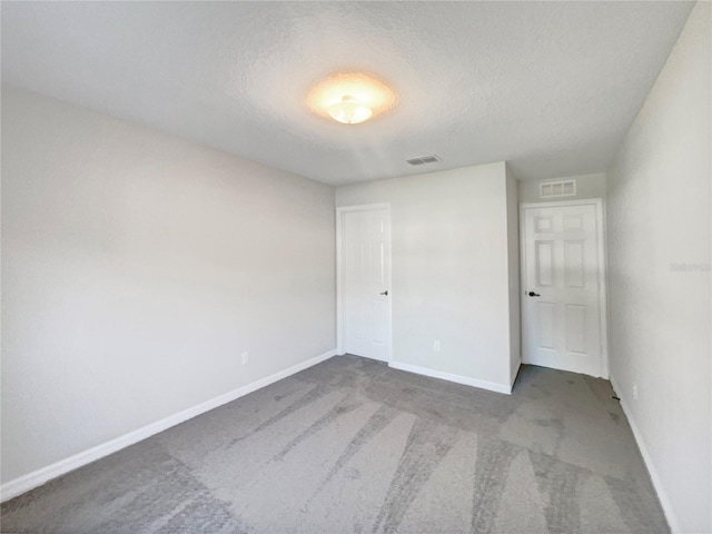 unfurnished bedroom featuring a textured ceiling and carpet flooring