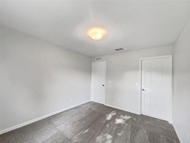 carpeted spare room featuring a textured ceiling