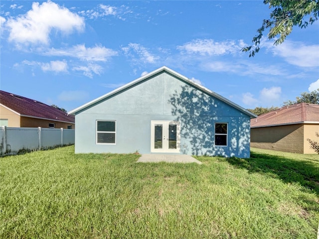 rear view of property featuring a lawn and french doors