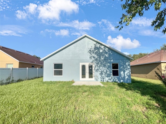 rear view of house with a lawn and french doors