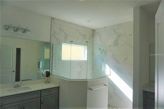 bathroom featuring a tile shower and vanity