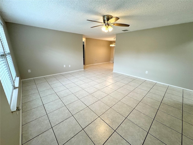 unfurnished room featuring light tile patterned flooring, a ceiling fan, visible vents, and a textured ceiling