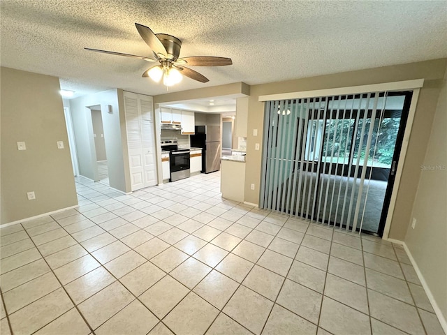 unfurnished living room featuring a textured ceiling, ceiling fan, and light tile patterned flooring