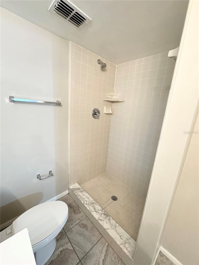 bathroom featuring visible vents, baseboards, toilet, and a stall shower