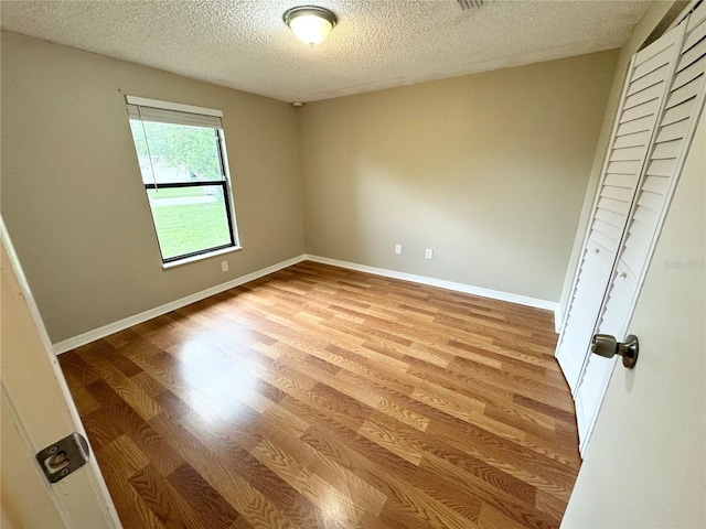 interior space with a textured ceiling and hardwood / wood-style floors