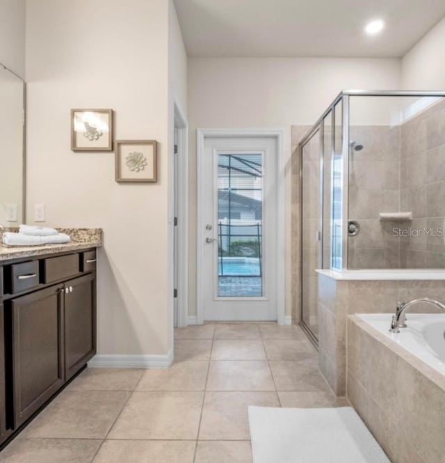 bathroom with tile patterned flooring, shower with separate bathtub, and vanity