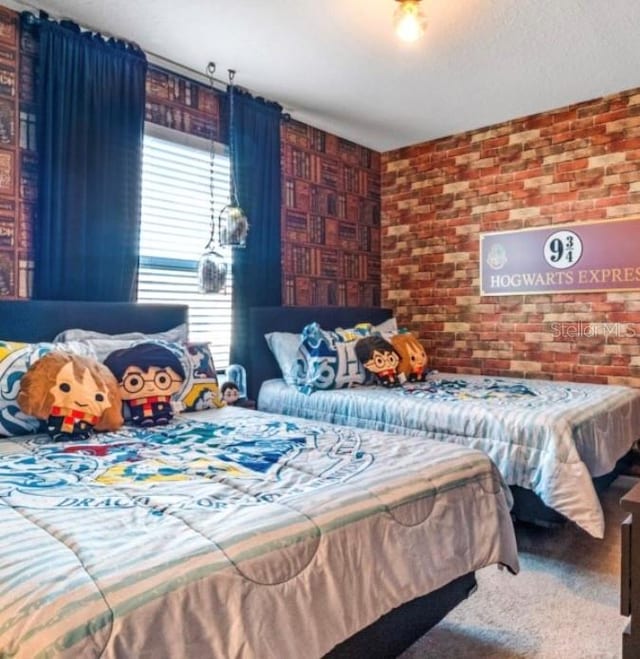 carpeted bedroom featuring brick wall