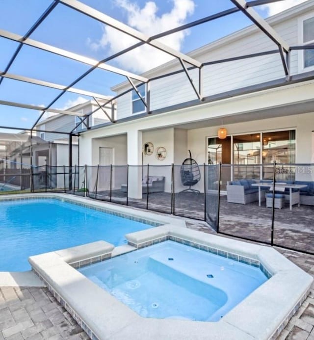 view of pool with a patio area, an in ground hot tub, a lanai, and outdoor lounge area