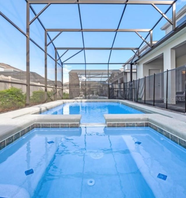 view of pool featuring glass enclosure