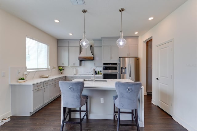 14007 Creek Harbor Dr, Orlando, FL 32824 - kitchen with a kitchen breakfast bar, appliances with stainless steel finishes, an island with sink, and gray cabinets